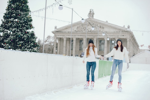 Cute and beautiful girls in a white sweater in a winter city