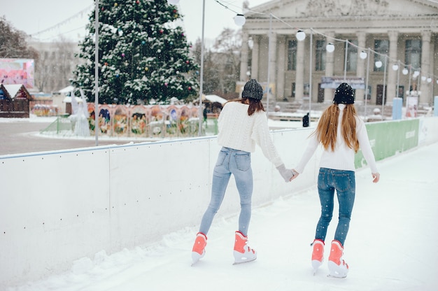 Cute and beautiful girls in a white sweater in a winter city