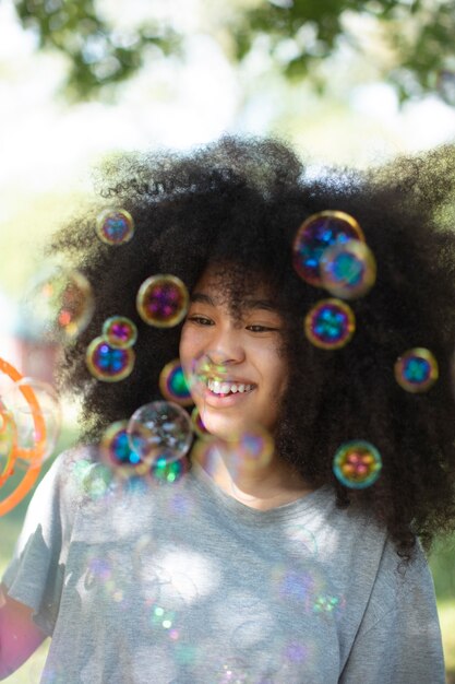 Free Photo cute black teenage girl playing with soap bubbles