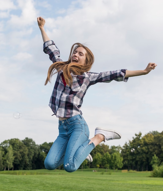 Free photo cute blonde girl jumping outdoors