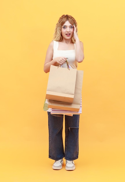 Cute blonde holding shopping bags and puts her hands to her forehead