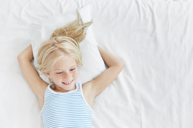 Free photo cute blonde little girl in bed