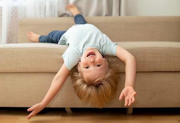 Free photo cute boy on couch playing