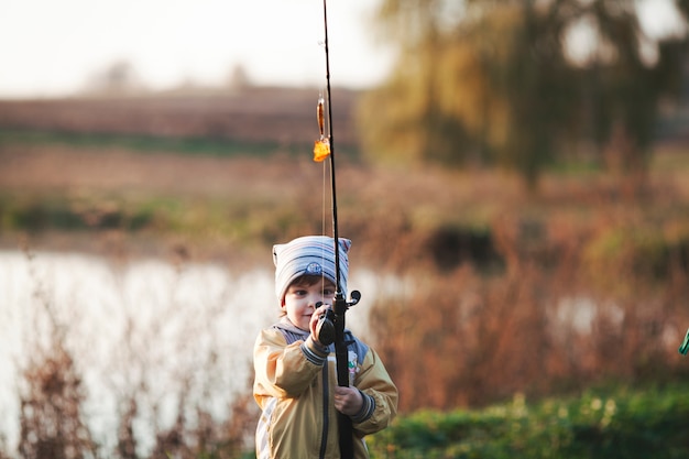 Free photo cute boy fishing near lake