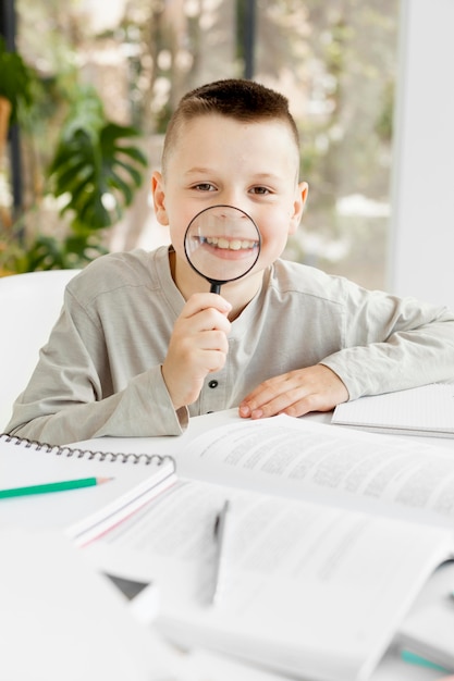 Cute boy fooling around with a magnifying glass