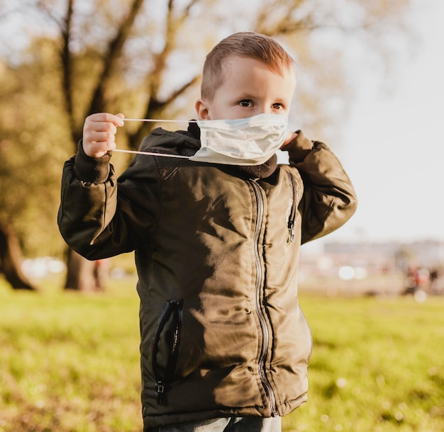 Cute boy wearing a medical mask in the park