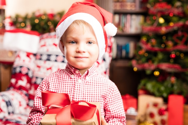 Cute boy with gifts and a santa hat