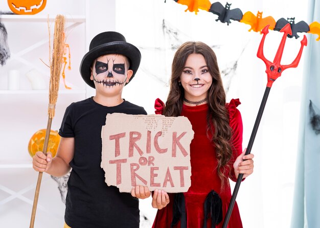 Cute brothers holding trick or treat sign for halloween