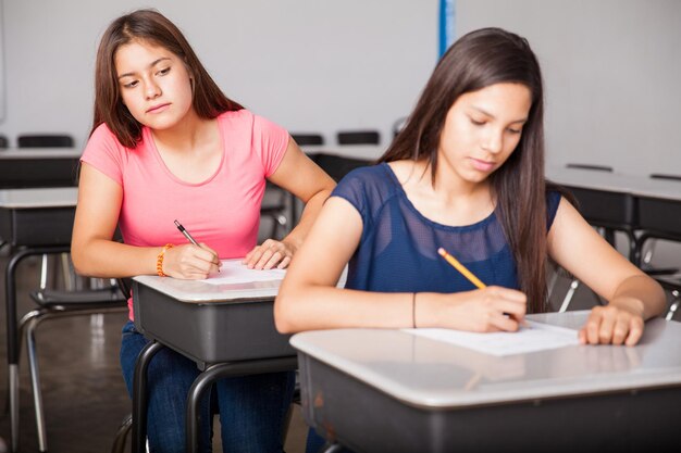 Cute brunette trying to cheat during a test in high school