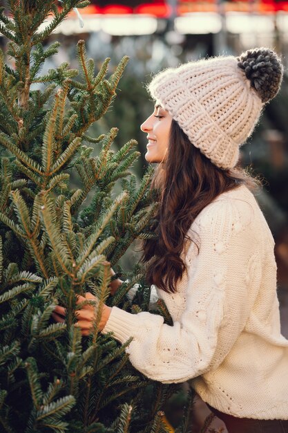 Cute brunette in a white sweater with Christmas tree