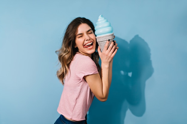 Free photo cute brunette woman in t-shirt posing with ice cream