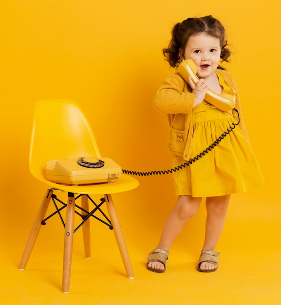 Cute child posing while holding telephone