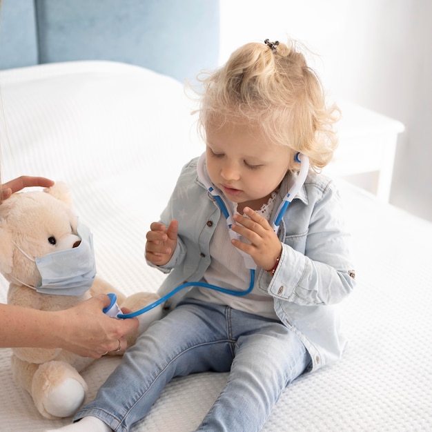 Cute child with toy and stethoscope at home during quarantine