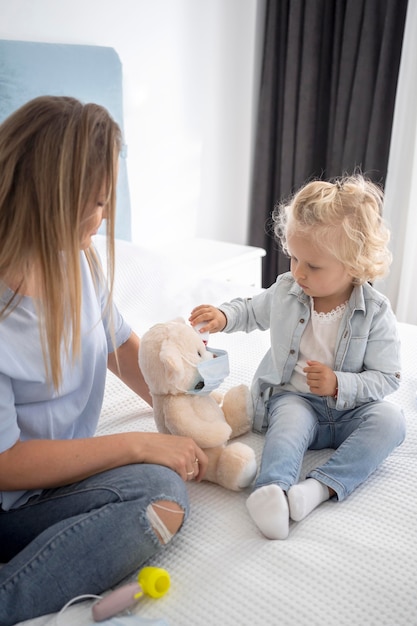 Cute child with toy and stethoscope at home during quarantine