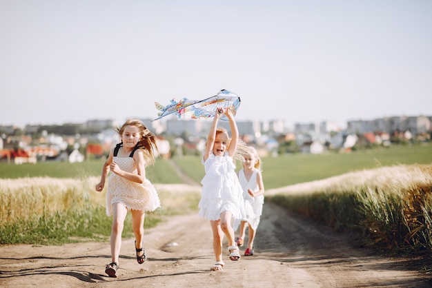 Free photo cute children spend time on a summer field