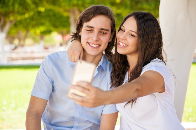 Free Photo cute couple of college students taking a selfie at school with a phone