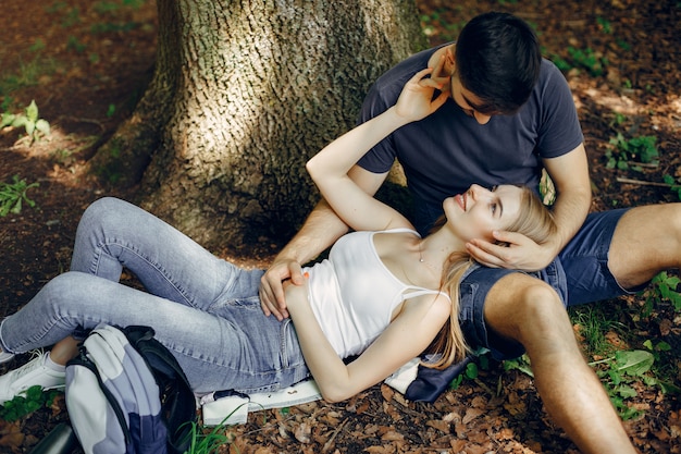 Free photo cute couple have a rest in a summer forest