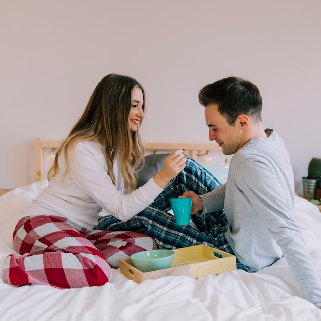 Free photo cute couple having breakfast in bed