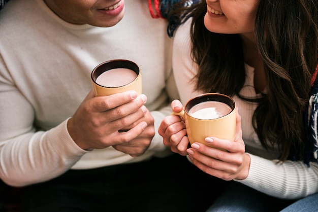 Free photo cute couple holding hot drinks