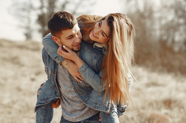 Cute couple in a jeans clothes in a spring field