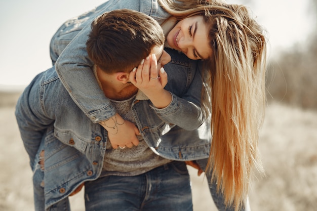 Free photo cute couple in a jeans clothes in a spring field