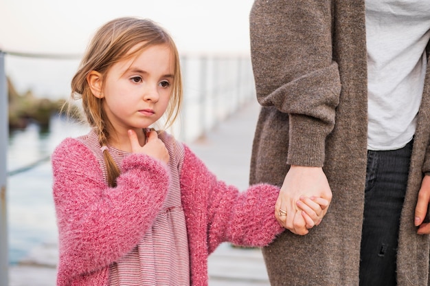 Cute daughter and mother holding hands