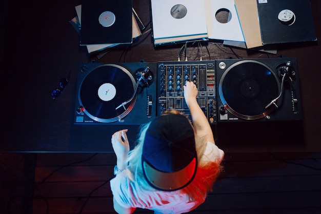 Cute dj woman having fun playing music at club party