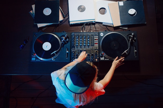 Cute dj woman having fun playing music at club party