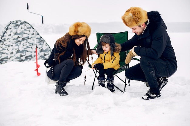 Free photo cute family sitting on a winter fishing with little son