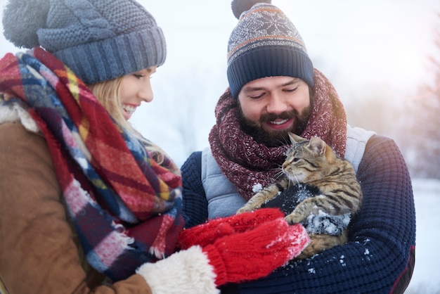 Free photo cute fluffy pet held by young couple