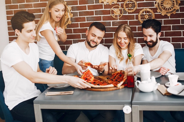 Free photo cute friends in a cafe eatting a pizza