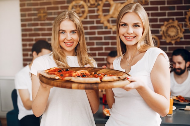 Free Photo cute friends in a cafe eatting a pizza