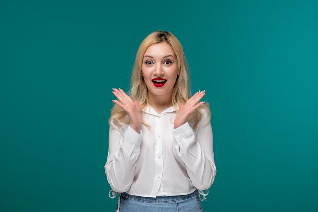 Cute girl blonde beautiful young girl in a white neat shirt super excited waving hands