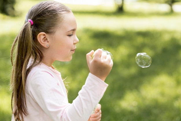 Cute girl blowing bubbles with her toy