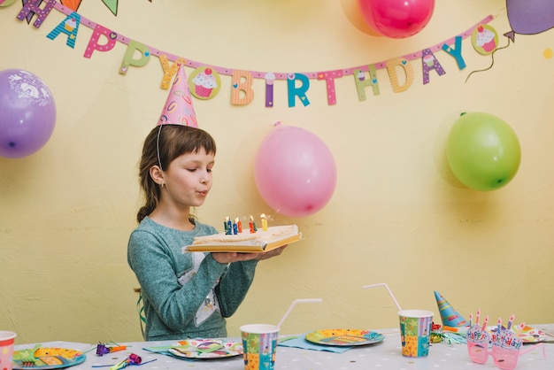 Cute girl blowing candles on cake