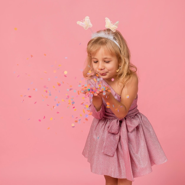 Cute girl blowing confetti