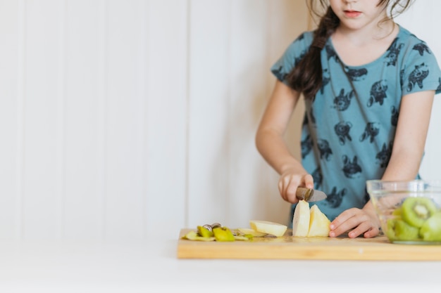 Free photo cute girl cutting pears