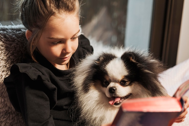 Free Photo cute girl and dog reading