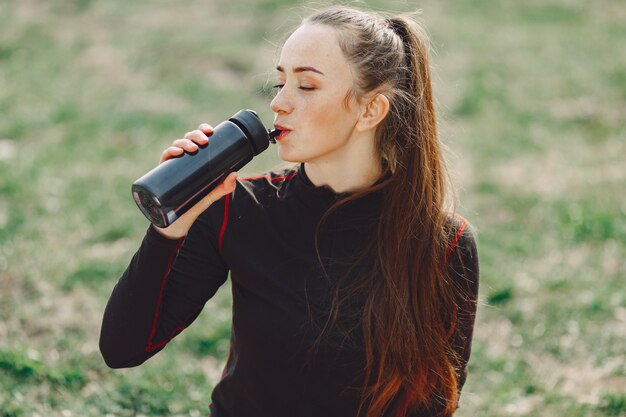 Cute girl doing yoga in a summer park