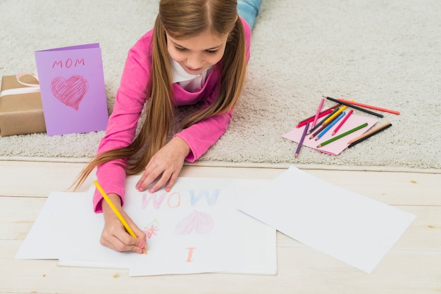 Free Photo cute girl drawing i love mom on paper