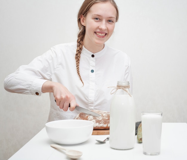 Free Photo cute girl having breakfast on a white table