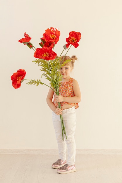 Free photo cute girl holding big red flowers