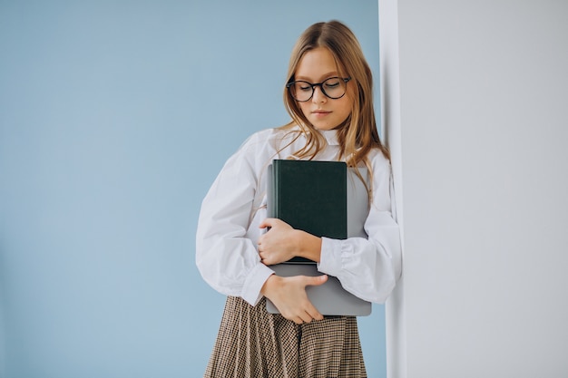 Cute girl holding book and laptop in the office