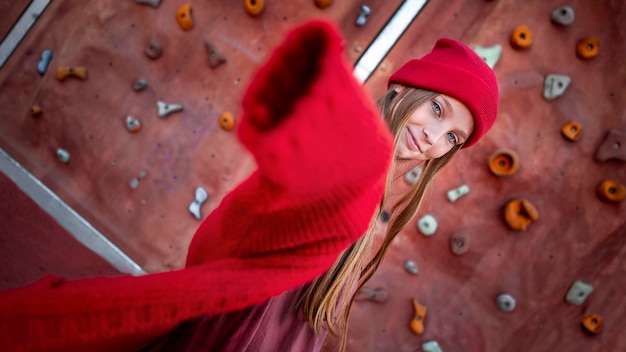 Free photo cute girl posing next to a climbing wall