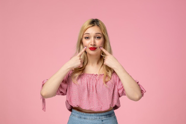 Cute girl pretty blonde lady wearing red lipstick in pink blouse holding cheeks looking sweet