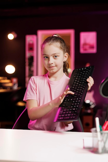 Cute girl showing viewers mechanical keyboard received from sponsoring brand to promote it