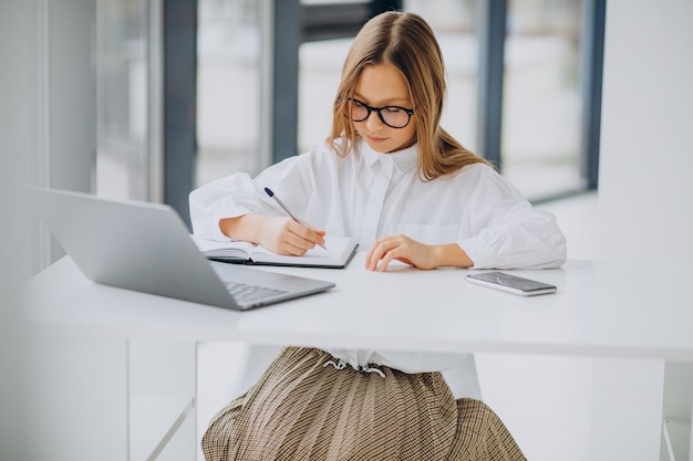 Cute girl studying on the computer at home