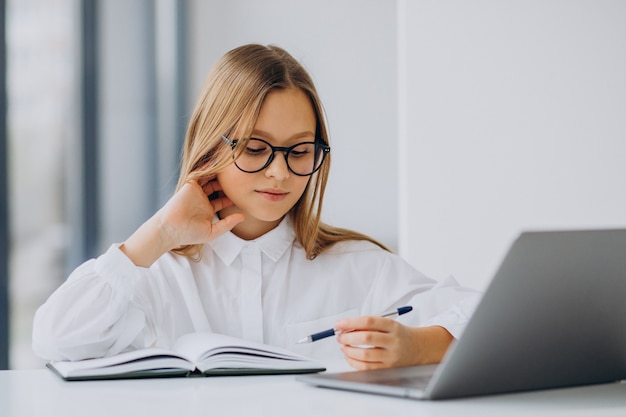 Cute girl studying on the computer at home