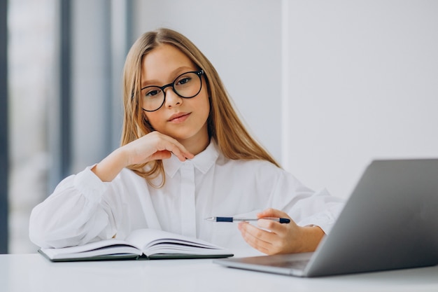 Cute girl studying on the computer at home