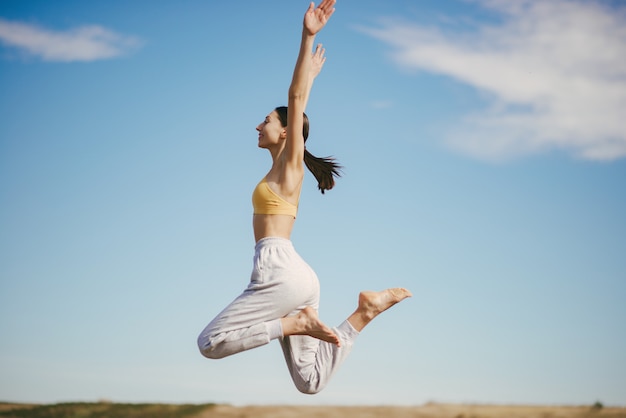 Cute girl training on blue sky